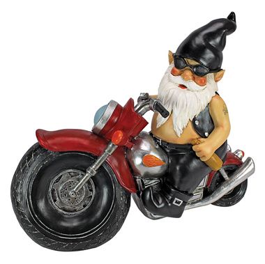 Biker gnome sitting on a motorcycle in a garden.